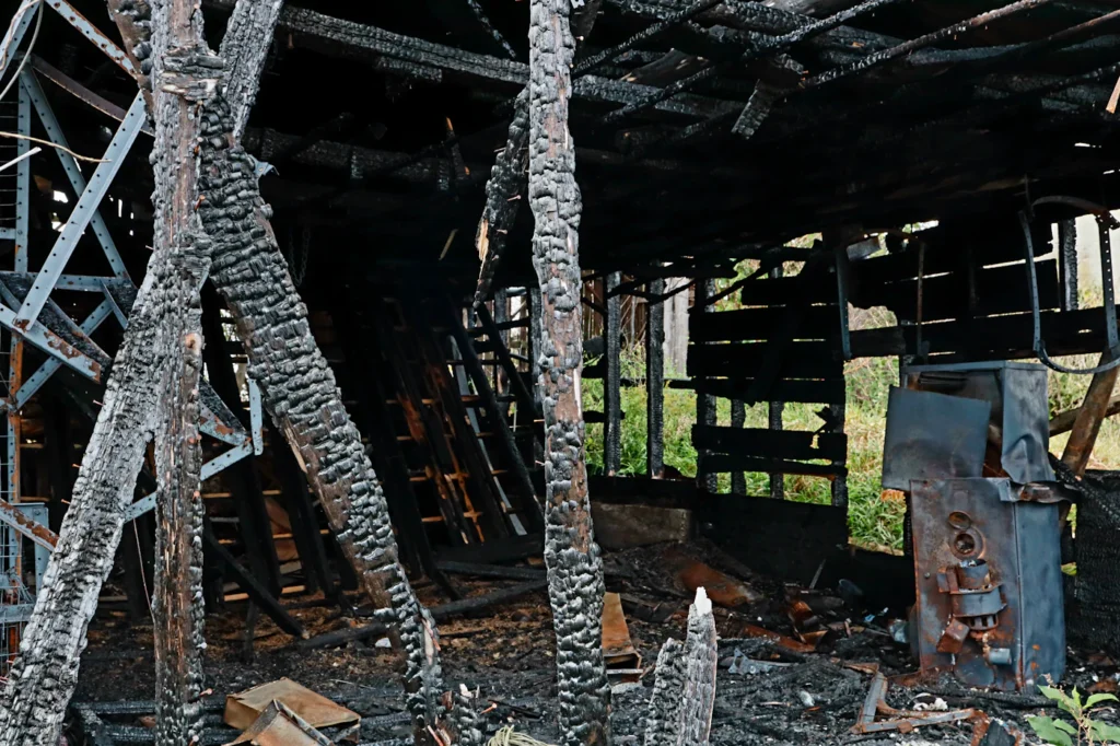 Charred wooden beams inside a fire-damaged structure