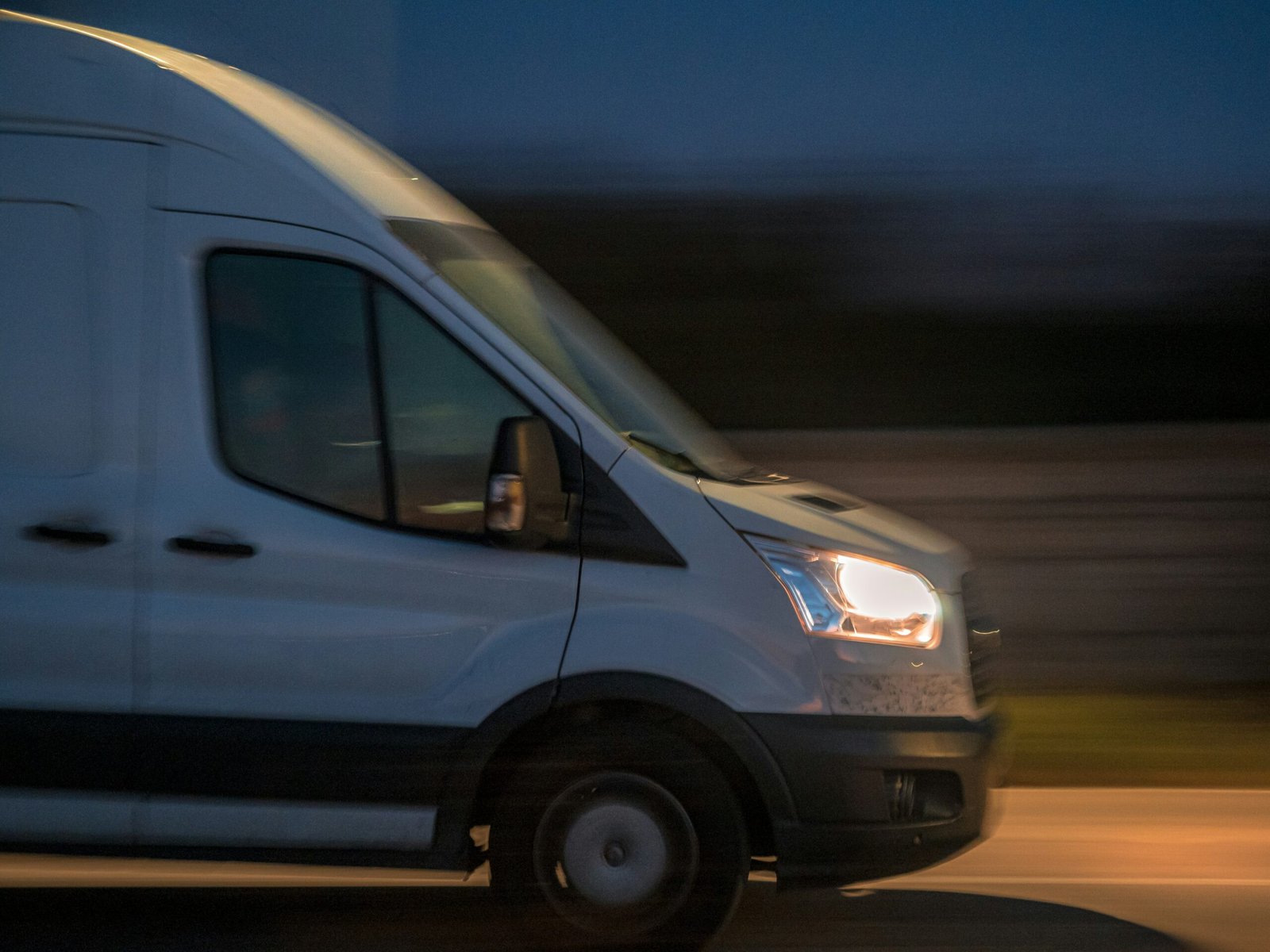 A response van driving down a street at night, representing round the clock emergency dispatch